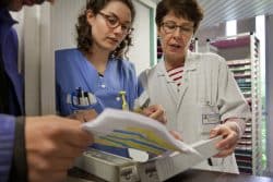 A l'accueil des patients, un détenu vérifie sa prescription avec les infirmières A l'accueil des patients, un détenu vérifie sa prescription avec les infirmières
