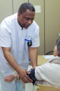 Christian Calcar infirmier prend la tension d'une patiente en consultation de suivi post AVC
