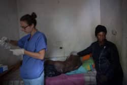 L'infirmière française, Marie Coutand, en coopération au Cameroun, change les pansements sur les escarres de ce patient