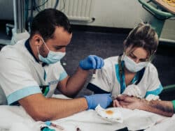 Mathilde, assistée d'un étudiant en soins infirmiers, effectue les premiers prélèvements sanguins sur un patient