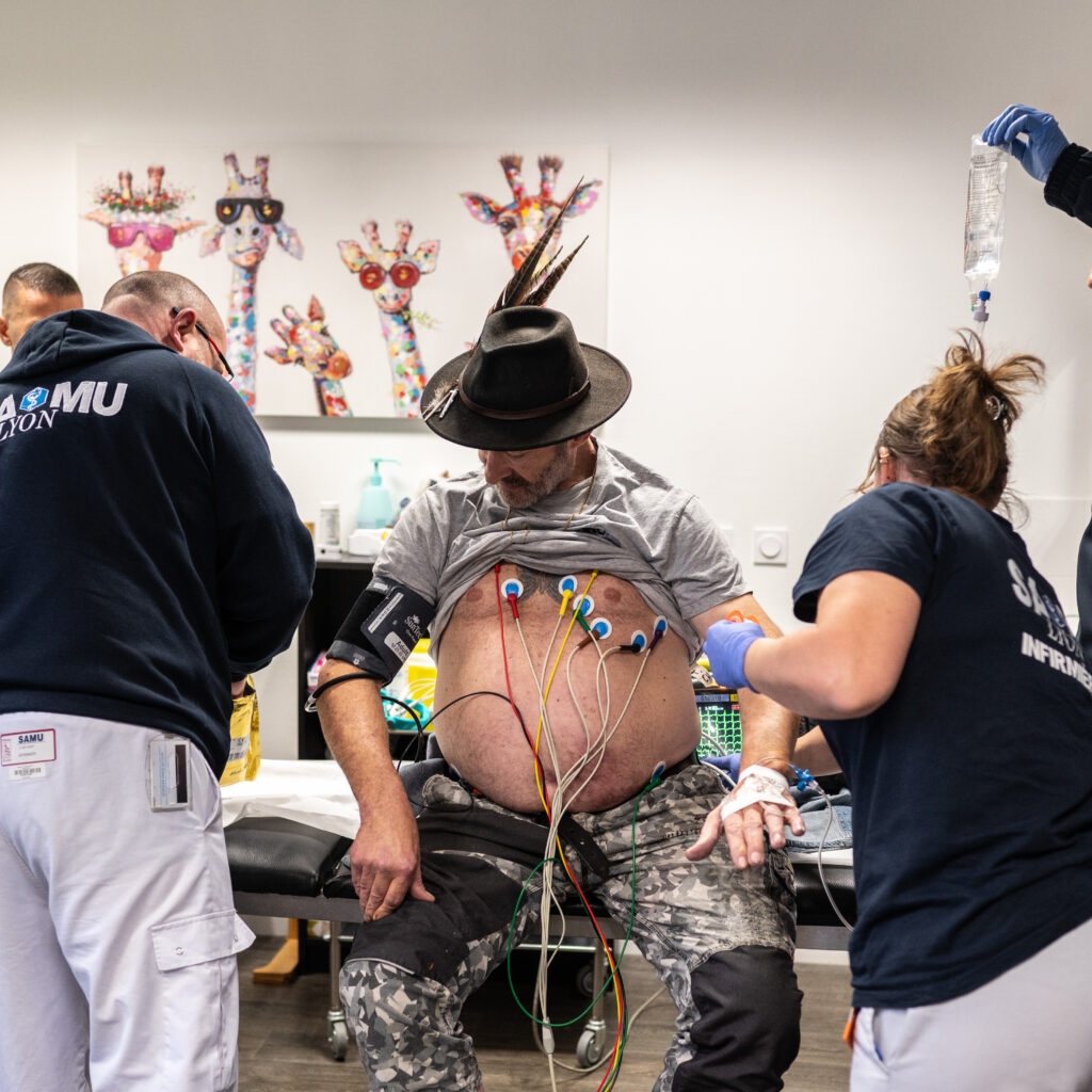 Les gardes de douze heures se suivent mais ne se ressemblent pas. Delphine Jomard accompagne Christophe, un patient souffrant d’une douleur thoracique, dans un cabinet médical. Le patient est monitoré par un scope à batterie, nécessaire pour suivre les paramètres vitaux, incluant un défibrilateur en cas d’arrêt cardiaque avec un rythme choquable. © Bastien Doudaine