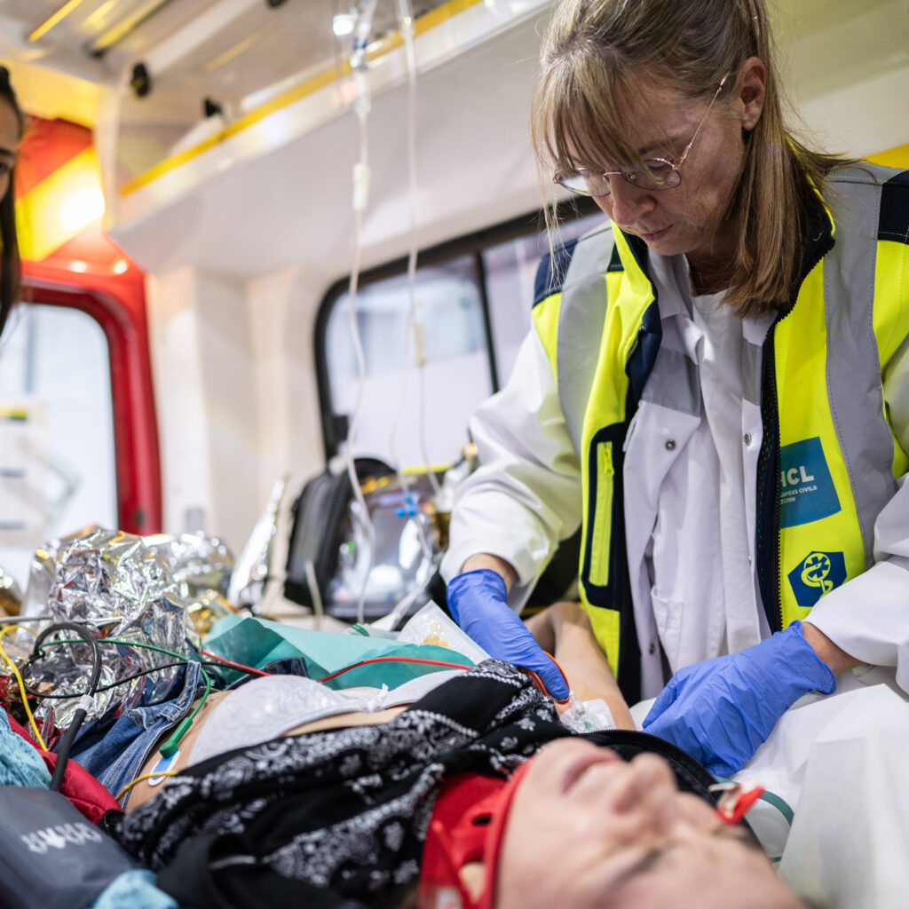 Les pompiers, souvent déclenchés aux premiers instants d’un appel pour une situation urgente, ont déjà effectué un premier bilan et installé la victime dans leur véhicule. L’équipe du SMUR peut évaluer la situation dans le calme, avec une efficacité redoutable malgré le contexte potentiellement stressant et l’espace restreint. La pose de voie veineuse périphérique fait partie des premiers gestes. © Bastien Doudaine