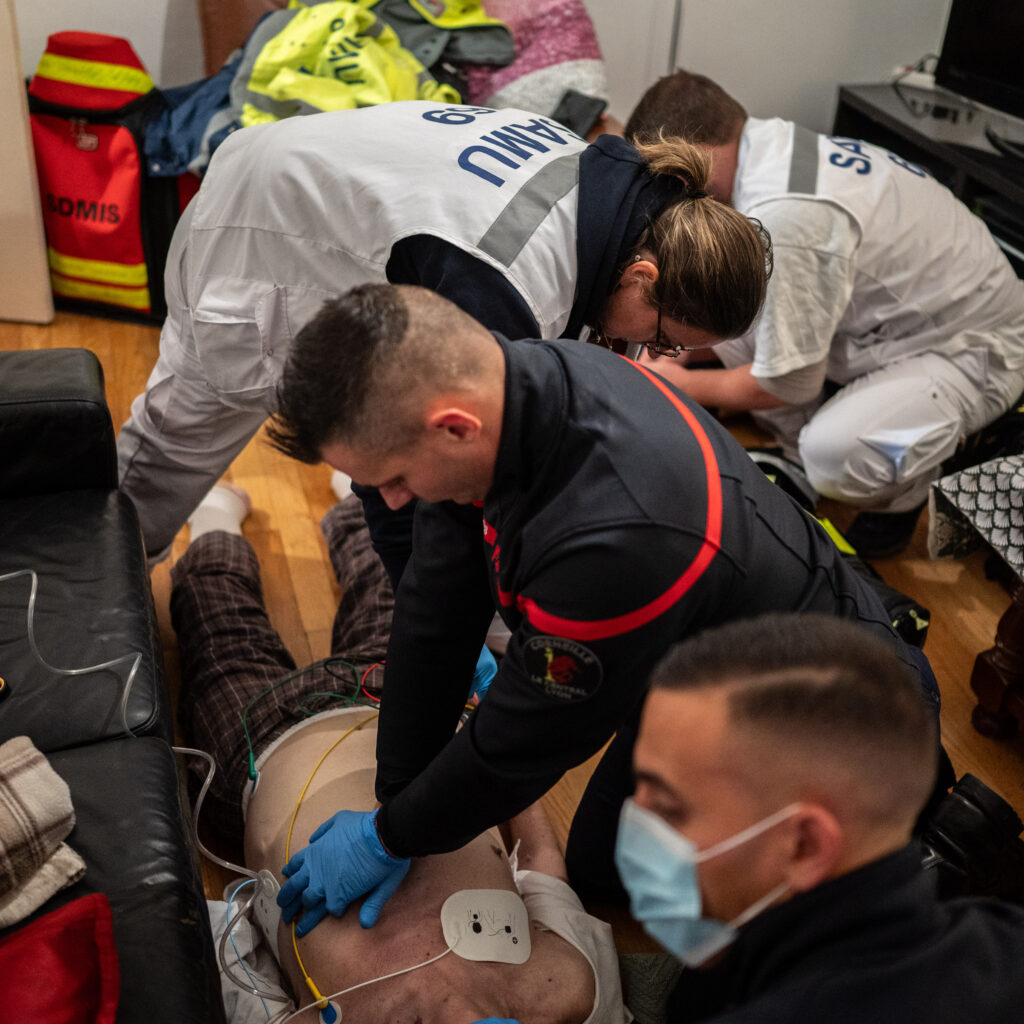 Le SMUR est régulièrement appelé pour des personnes en arrêt cardiorespiratoire. Pendant que les pompiers se relaient aux compressions thoraciques, Anne-Sophie Dufaud, infirmière, pose une voie et passe l’adrénaline en coordination avec l’urgentiste. À Lyon, quinze infirmiers sont aussi, pour l’instant, formés à l’ECMO, un dispositif de circulation extra-corporelle utilisé dans les arrêts cardiaques réfractaires. © Bastien Doudaine